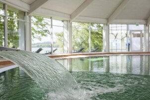 Una piscina techada, sillones reclinables de piscina