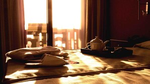 A hotel room with a bed, a nightstand, a lamp, and a window with curtains. - Campos de Baeza (Baeza)