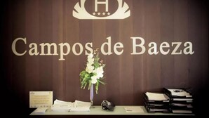 A reception desk with a sign reading "Campos de Baez" and a logo above it. - Campos de Baeza (Baeza)