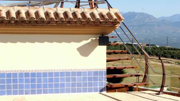 Une piscine dotée d’un plongeoir et offrant une vue sur les montagnes en arrière-plan.