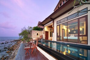 A modern house with a pool, a deck with chairs, and a view of the ocean. - The Sarann Koh Samui, Suites & Villas (Koh Samui)
