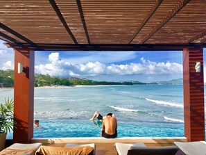 Una piscina al aire libre, sombrillas, sillones reclinables de piscina