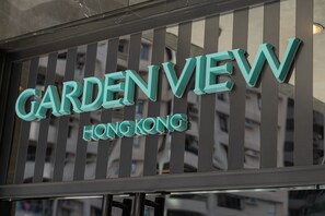 Placa com as palavras 'GARDEN VIEW' e 'HONG KONG', indicando o nome de um hotel ou propriedade.