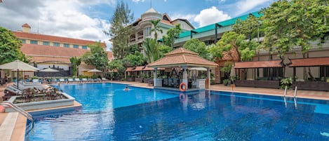 Alberca al aire libre, sombrillas en la alberca y camastros