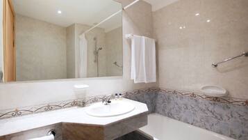 A bathroom with a sink, mirror, shower, and bathtub.