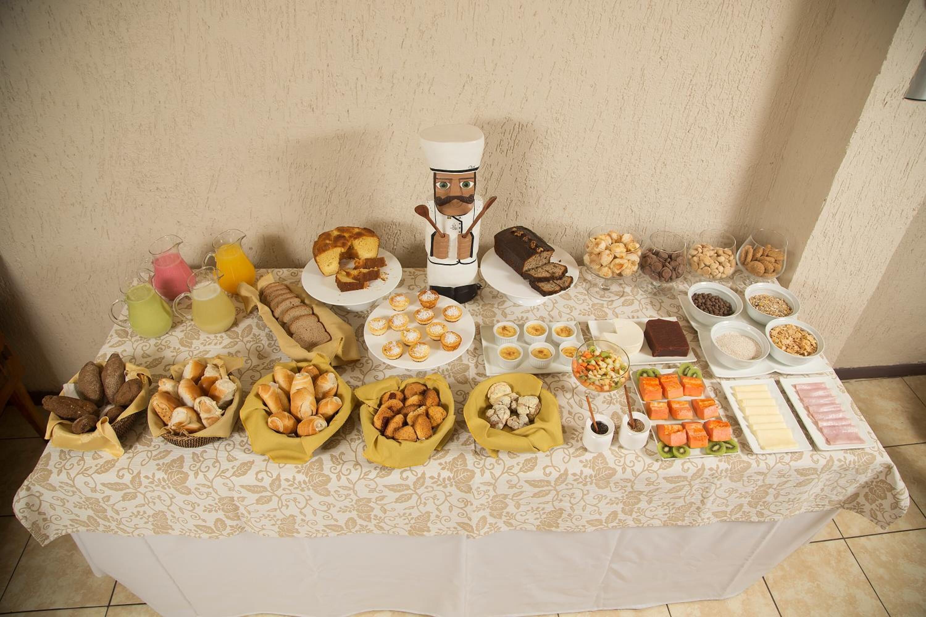 A buffet table with various food items and a chef figurine.