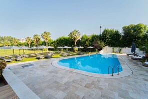 حمّام سباحة خارجي، مظلات على حمّام السباحة، مقاعد للتشمس