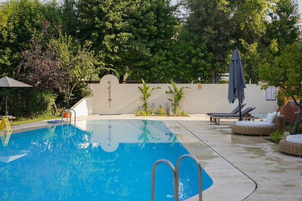 Piscine extérieure, parasols de plage, chaises longues