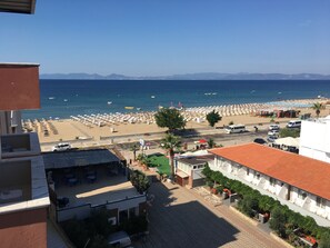 Vista costera con playa, sombrillas y cielo despejado.