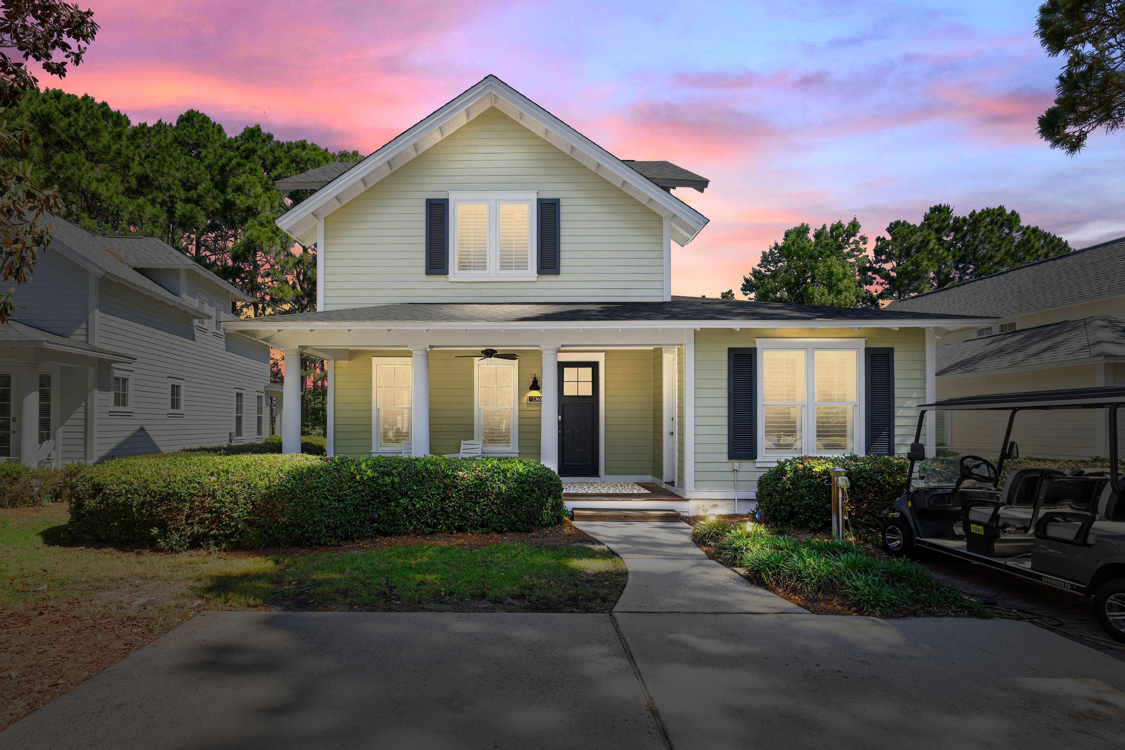 A two-story house with a front porch, a garage, and a golf cart parked outside.