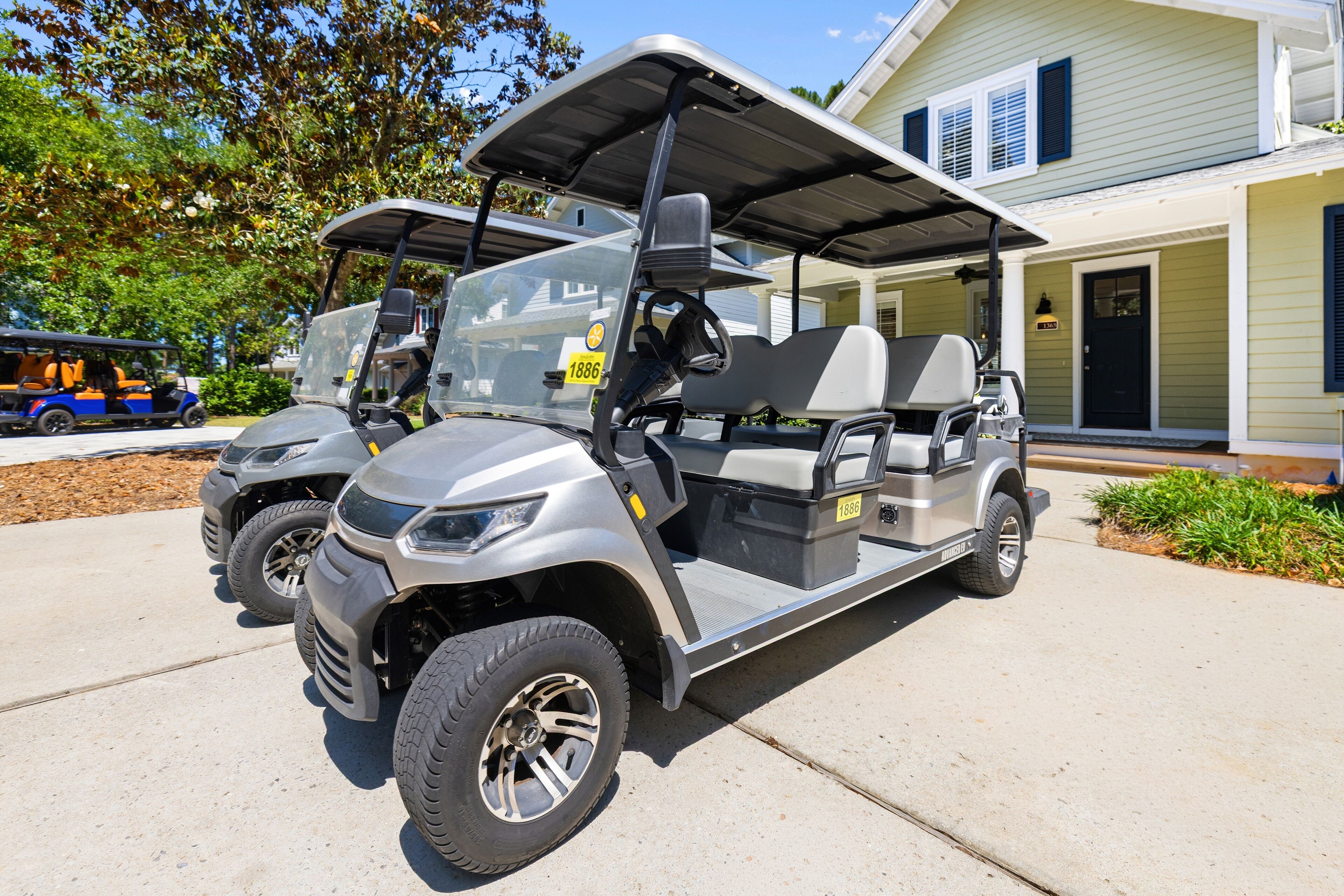 A golf cart parked in front of a house with a garage and a covered porch.