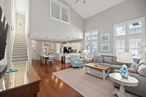 A spacious living area with a staircase, a kitchen, and a dining area.