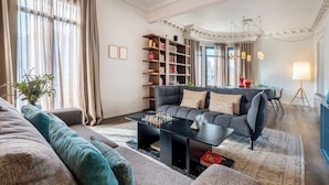 Un salon moderne comprenant un canapé, une table basse, une bibliothèque et un coin repas.