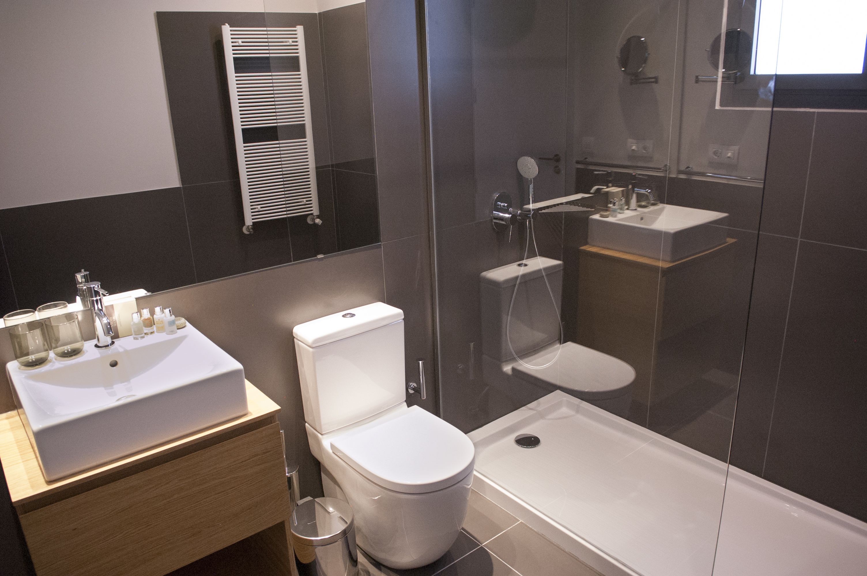 Un baño moderno con lavamanos, inodoro y ducha blancos.