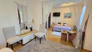 A bedroom with a bed, bedside table, chair, and a mirror. - Avalena Residence (Zadar)