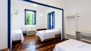 A hotel room with two beds, a desk, a chair, and a wardrobe. - Farfalla Guest House (Rio de Janeiro)