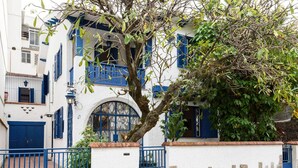 A white building with blue shutters and a tree in front. - Farfalla Guest House (Rio de Janeiro)