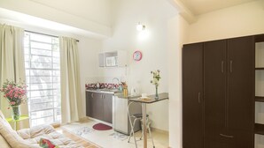 A compact living space with a kitchenette, a dining area, and a sofa. - Jovita House BnB (Cali)