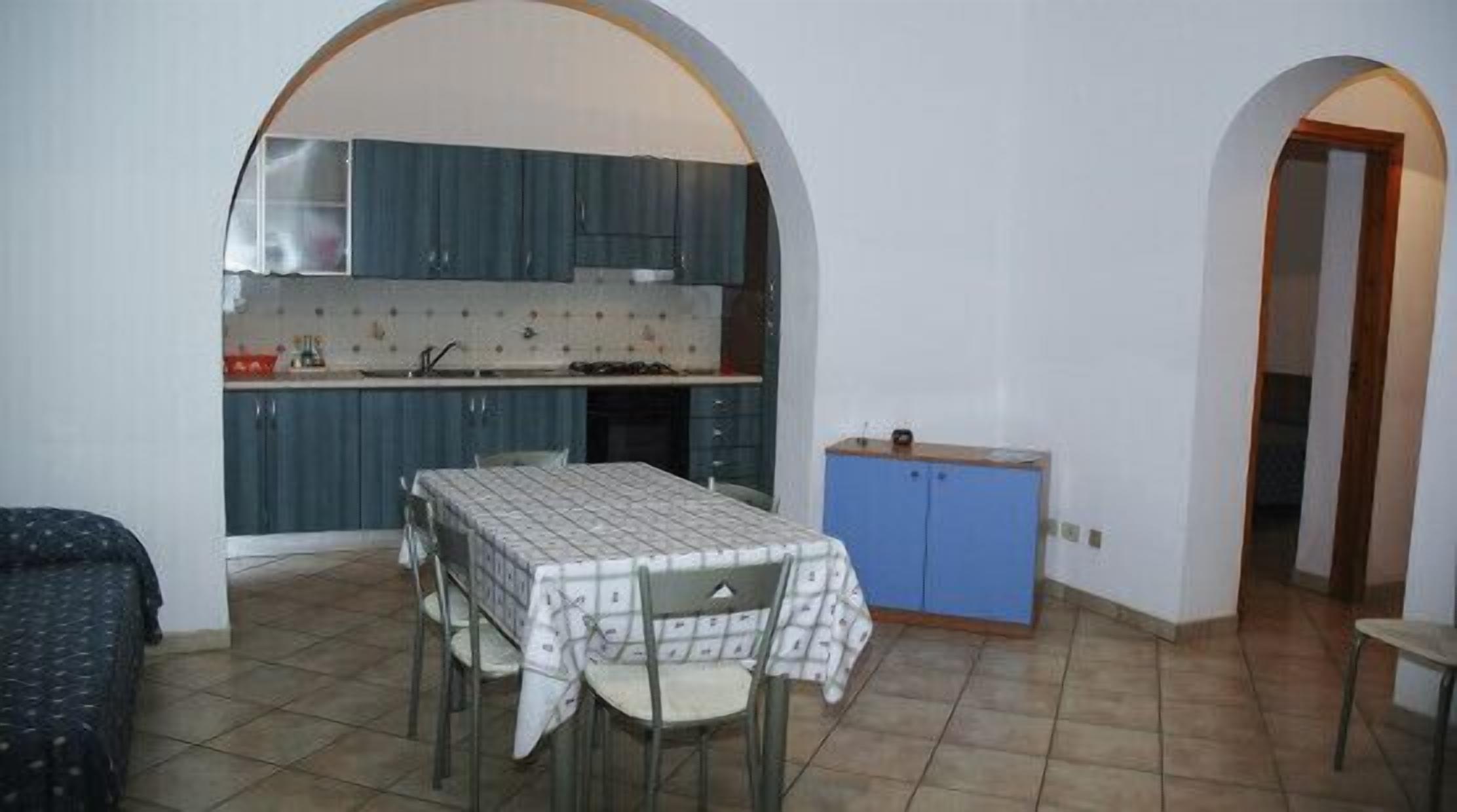 Een ruimtelijke leefruimte met keuken, eethoek en een slaapkamer.
