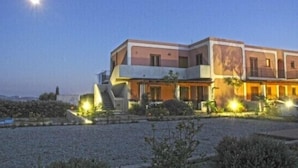 A two-story house with a flat roof and a balcony on the upper floor. - Eolian Residence (Lipari)