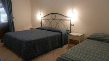 Un dormitorio con cama, mesita de noche y lámpara de pared.