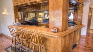 A kitchen with wooden cabinetry, a central island with bar stools, and a large window. - 569 Lucerne 4 Bedroom Home by RedAwning (South Lake Tahoe)