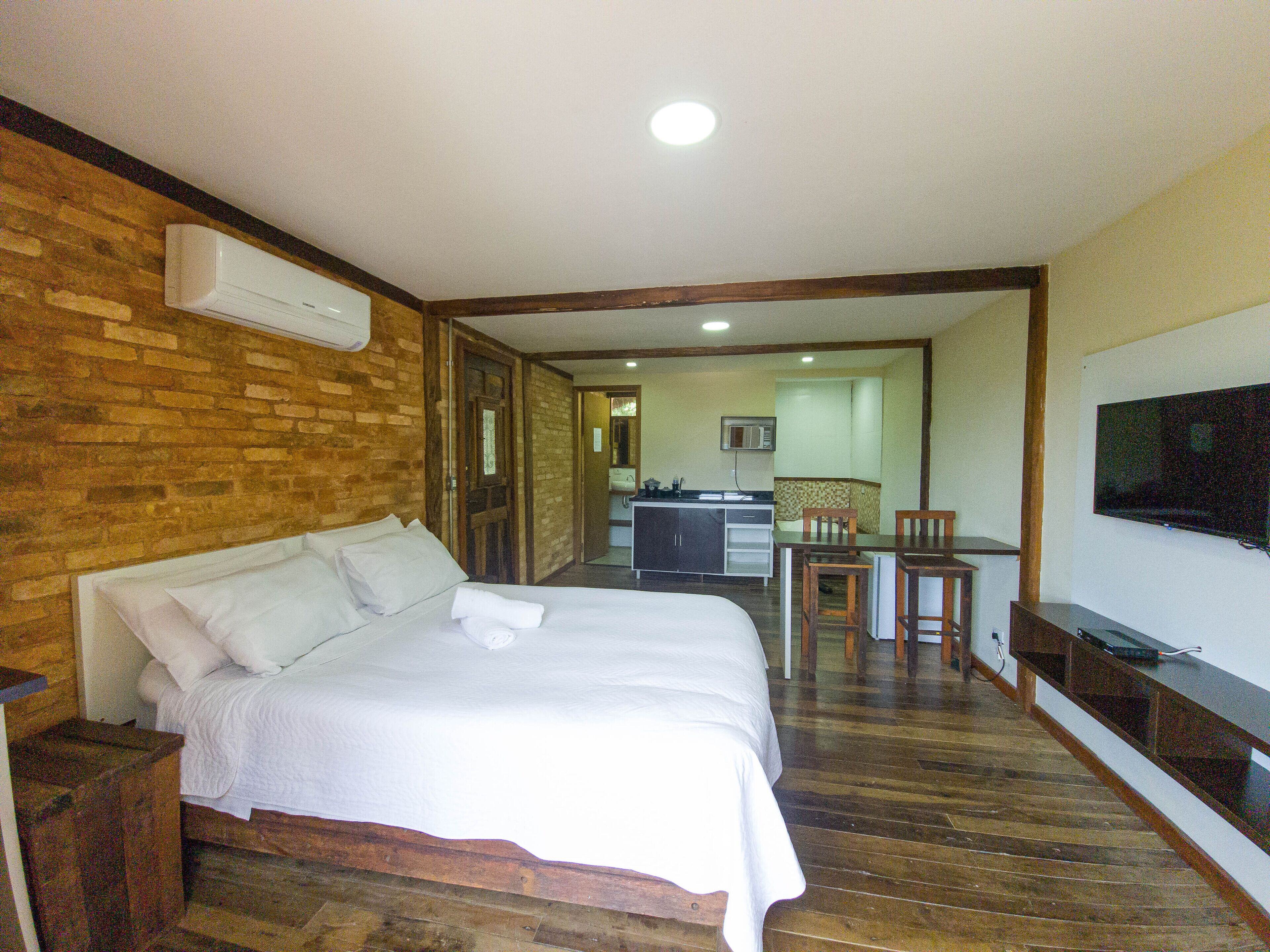 Une chambre d’hôtel équipée d’un lit, d’une télévision, d’une kitchenette et d’un coin repas.