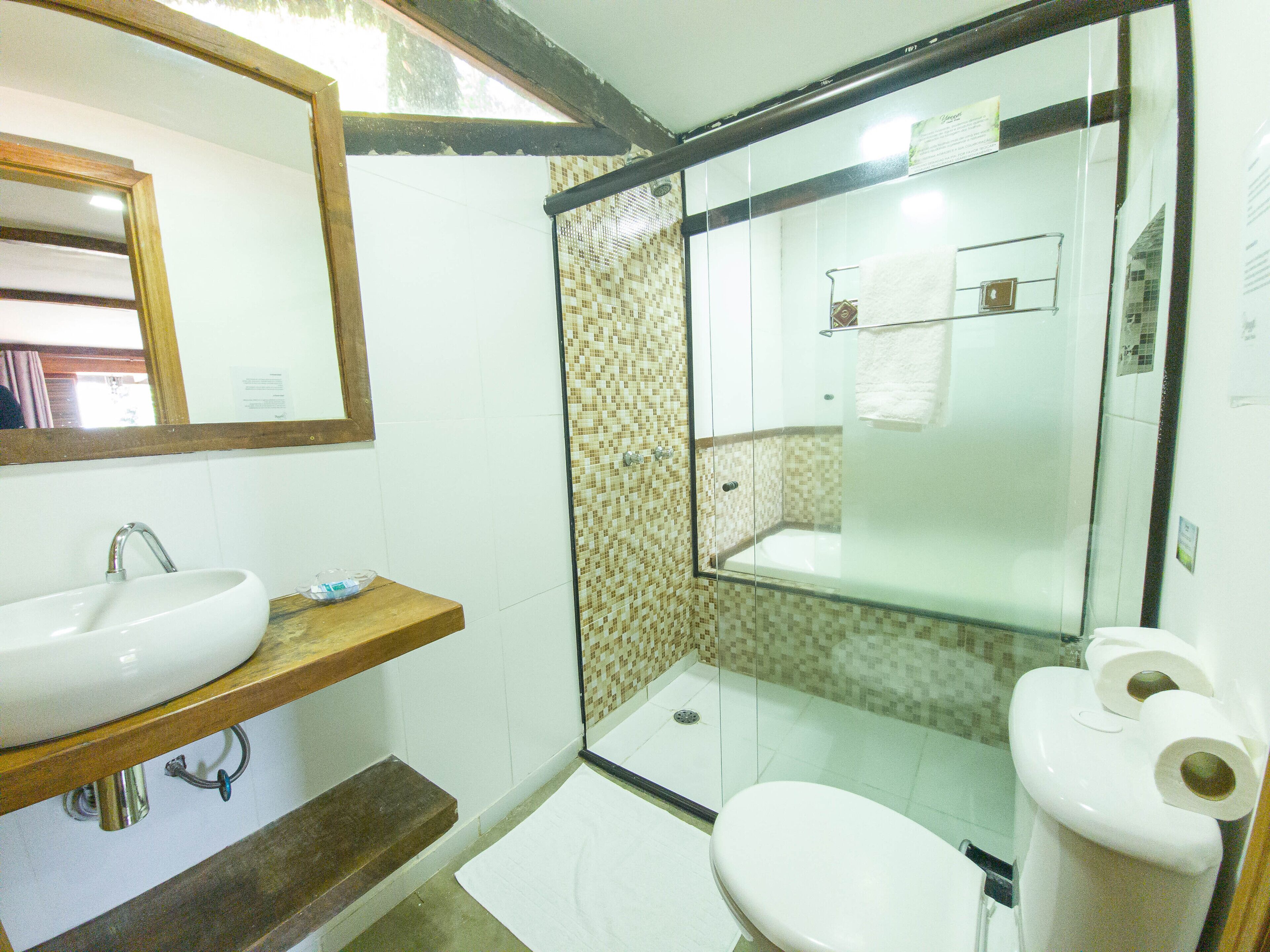Un baño con lavamanos, inodoro y zona de ducha.