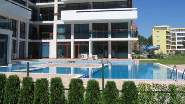 A multi-story hotel with a swimming pool and a well-maintained lawn. - Villa Itta (Sunny Beach)