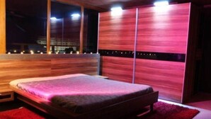 A modern bedroom with a bed, a nightstand, and a large window. - Villa Itta (Sunny Beach)