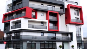 A modern multi-story building with a combination of white, black, and red exterior colors. - Tempo Hotel Targu Mures (Tirgu Mures)