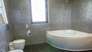 A modern bathroom with a freestanding bathtub, a toilet, and a sink. - Tempo Hotel Targu Mures (Tirgu Mures)