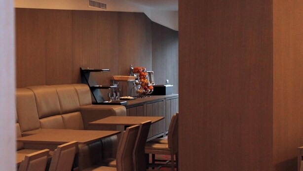 A restaurant with a booth seating area, a counter with a fruit display, and a patterned carpet. - Tempo Hotel Targu Mures (Tirgu Mures)