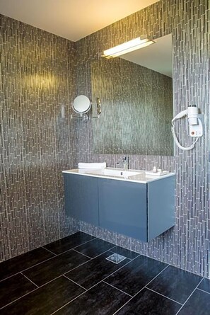 A modern bathroom with a large mirror, a dual sink vanity, and a wall-mounted towel rack.