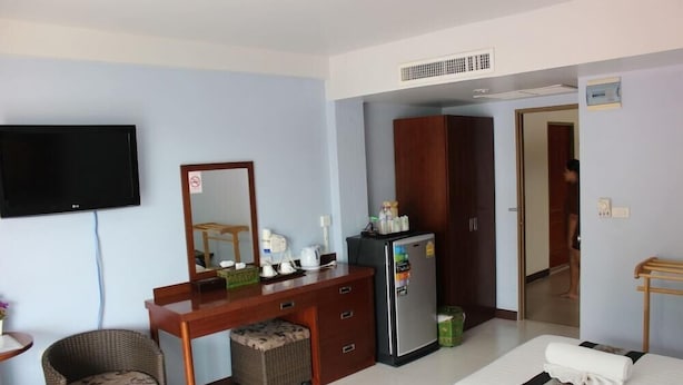 A hotel room with a bed, a desk with a computer, a television, a wardrobe, and a refrigerator. - Nap Inn (Ko Pha-ngan)
