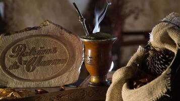 Un conjunto tradicional para preparar yerba mate, que incluye una calabaza y un vaso cimbalino, acompañado de una bandeja de metal con un logo.