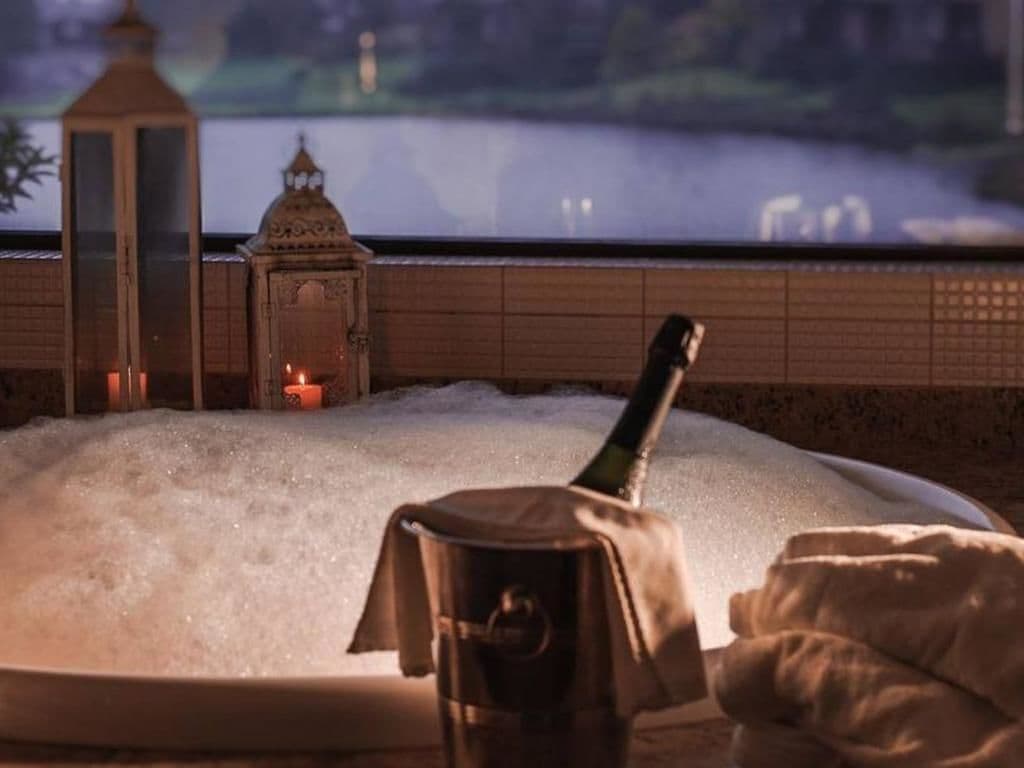 Un jacuzzi con vistas a un cuerpo de agua y un farol al fondo.