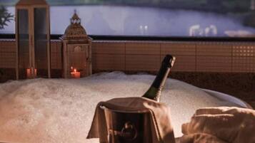 Un jacuzzi con vistas a un cuerpo de agua y un farol al fondo.