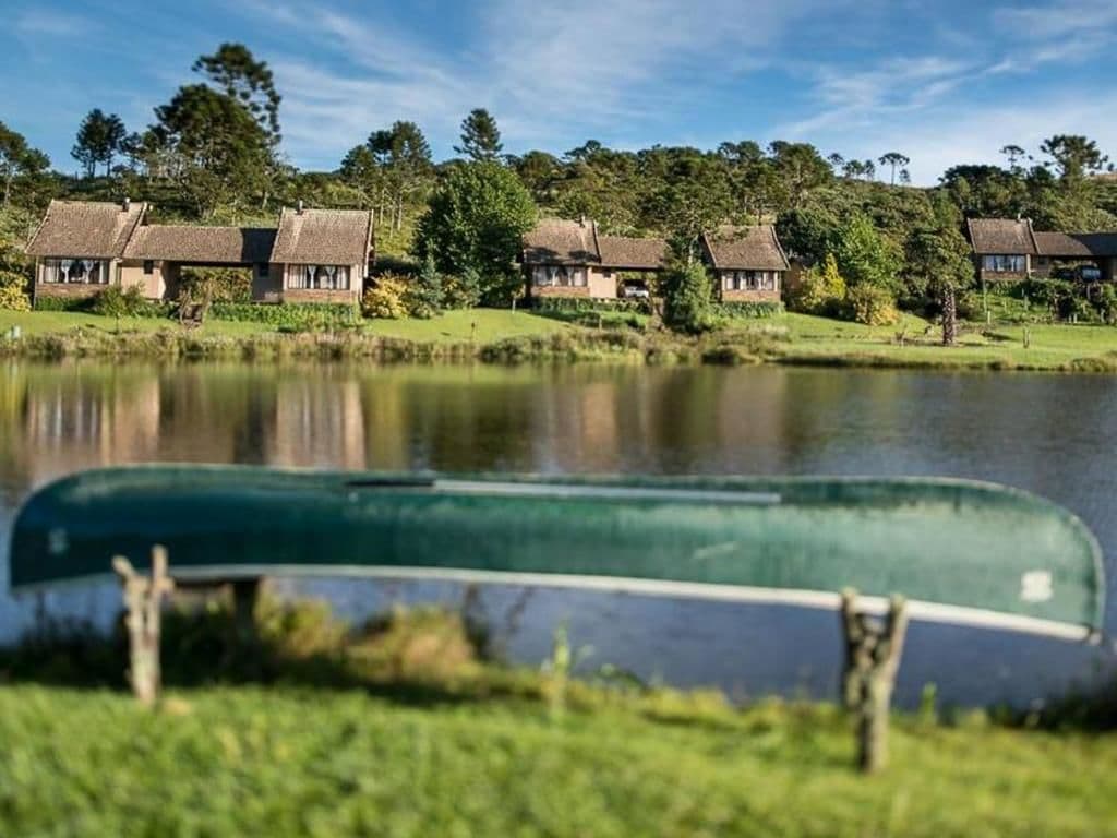 A row of traditional cottages by a lake with a boat in the foreground.