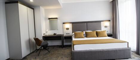 Une chambre d’hôtel moderne, dotée d’un grand lit, d’un bureau et d’une chaise.