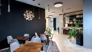 A modern interior with a dining area, a bar, and a decorative wall piece. - Best Western Plus Premium Inn (Sunny Beach)