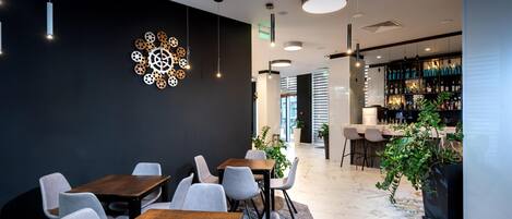 A modern interior with a dining area, a bar, and a decorative wall piece.
