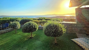 A landscaped garden with neatly trimmed bushes and a stone wall. - Paros Afrodite Luxury Villas (Paros)