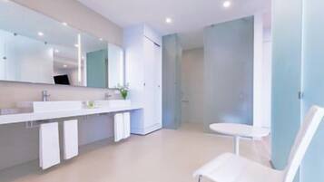 Een moderne badkamer met een grote spiegel, een witte wastafel en een witte stoel.