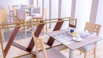 Een moderne eetruimte met houten stoelen en tafels, een glazen scheiding en een strak, minimalistisch design.