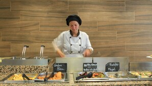 A buffet setup with labeled food options including 'Gordon Bleu' and 'Fischfillet Mujol'. - Hotel Garbí Cala Millor (Sant Llorenc des Cardassar)
