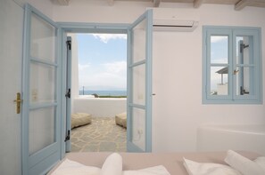 Habitación con vista al mar, una bañera y un espejo junto a la ventana.