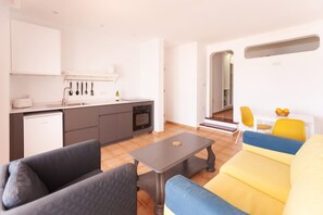 A modern kitchen with a built-in oven and a dining area with a yellow sofa and a small table. - Princesa Ico (Tías)