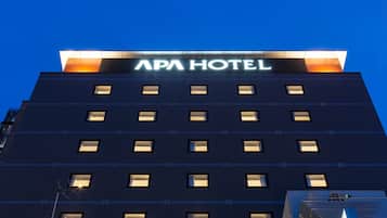 A building with the sign "APA HOTEL" on the top.
