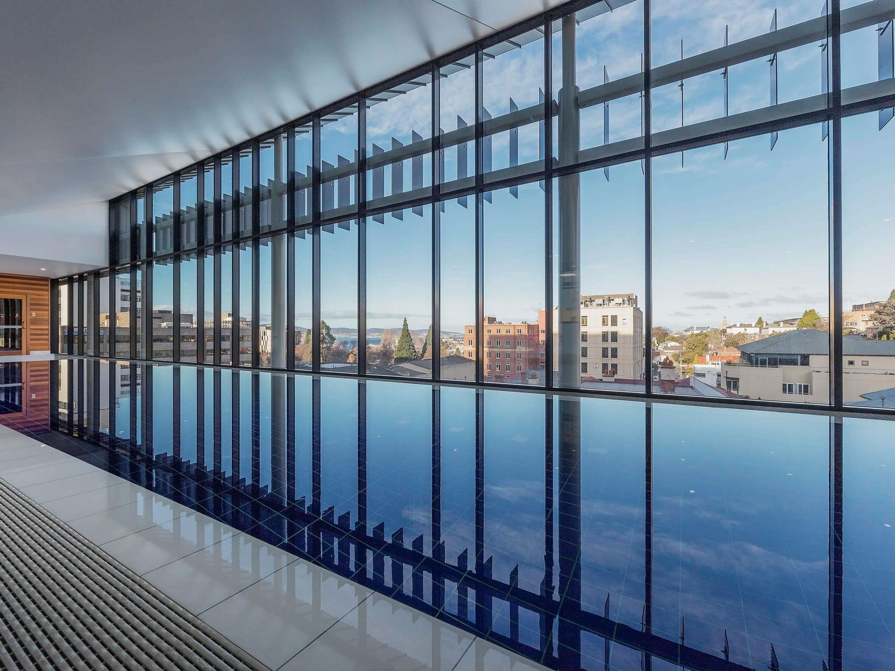 A modern building with large windows and a view of the cityscape.